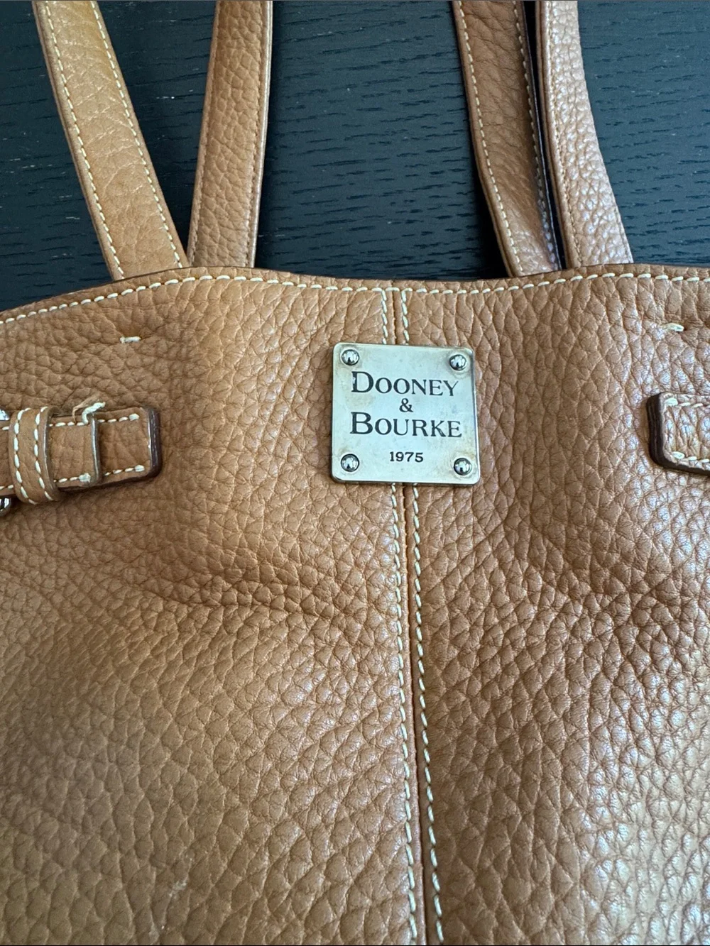 Dooney & Bourke tan pebbled leather side pockets belted satchel bag.